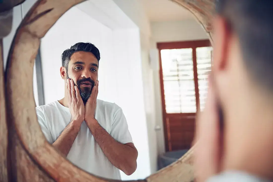 A man looking in the mirrror suffering from depression and low testosterone