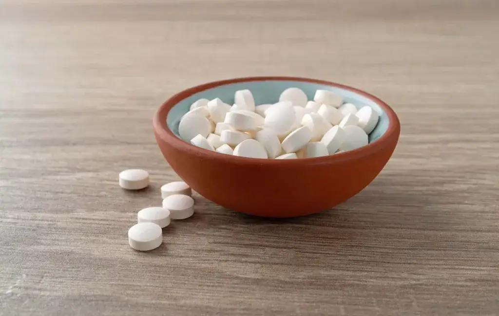 DHEA hormone supplement tablets in a bowl