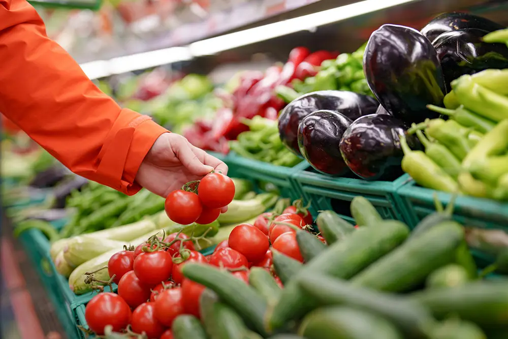 a man shopping for fruits and vegetables on a budget